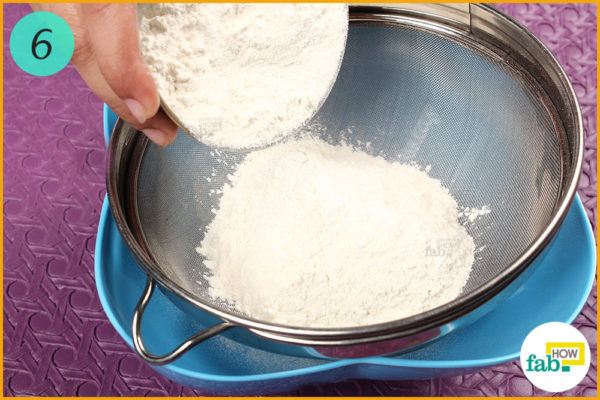 Put flour into a strainer